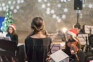 the conductor standing in front of the orchestra