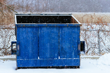 Trash bin at the side of street in winter with lip open