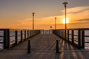 Fototapeta premium Wooden pier with view of Baltic Sea at sunset time. Hel Peninsula,Kuznica village in Poland.
