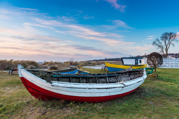 Fototapeta na wymiar Old fishing boat on the shore of Baltic Sea in Kuznica village on Hel Peninsula in Poland.