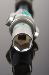 Socket wrench head close up isolated on the black reflective background