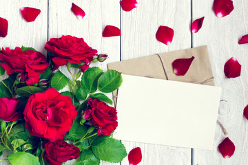 blank greeting card and envelope with red roses flowers and petals