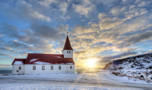 Typical red colored wooden church in Vik town, Iceland in winter.