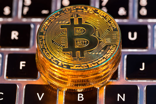 Bitcoin gold coins with laptop keyboard. Virtual cryptocurrency concept.