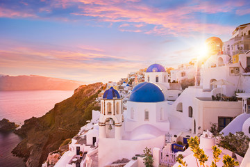 Sunset view of the blue dome churches of Santorini, Greece. - obrazy, fototapety, plakaty