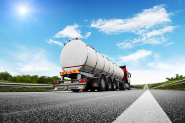Rear view of big metal fuel tanker truck shipping fuel against sky
