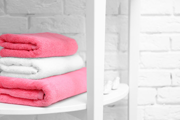 Obraz na płótnie Canvas Stack of clean towels on shelf in bathroom