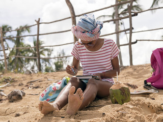 Girl draws watercolor on the beach
