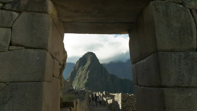 huayna picchu framed by a stone doorway at peru's famous lost inca city of machu picchu