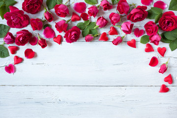 Roses and red hearts on a wooden background