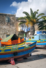 Fototapeta na wymiar maltese traditional painted luzzu boats in marsaxlokk fishing village malta