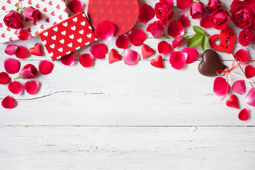 Roses and red hearts on a wooden background and gifts in boxes