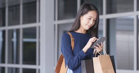 Fototapeta premium Woman use of mobile phone and shopping bag