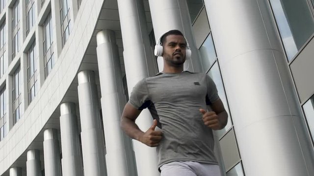 Slow-motion of determinated person running in headphones, workout motivation