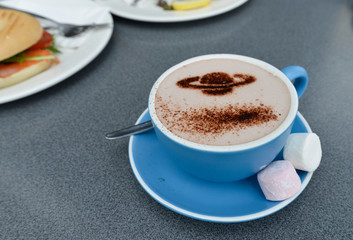 Cup of coffee with cream foam as Saturn
