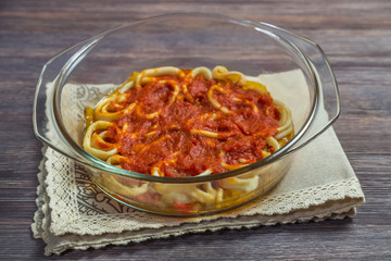 Squid rings with vegetables and tomato sauce in an ovenproof dish