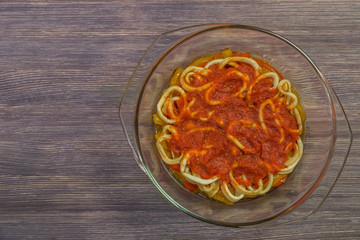  Squid rings with vegetables and tomato sauce in an ovenproof dish. The view from the top. Copy-space  