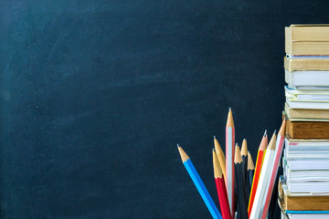 Pencils and books with chalkboard background. Education concept.