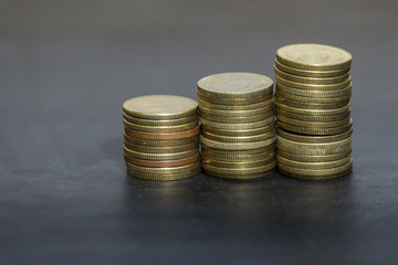 Row of coins on chalkboard background. Education concept. Selective focus.