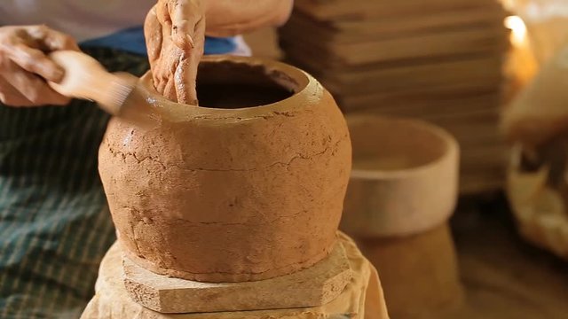 Potter at work. Close-up of woman making ceramic pot on the pottery wheel.
