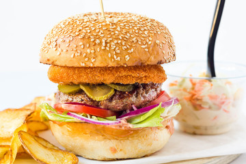Fresh burger with potato and coleslaw salad on white background.