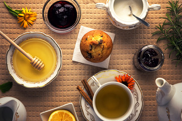 Beautiful arranged tea set up. Tea cup, honey , lemon and sweets on top of the table. 