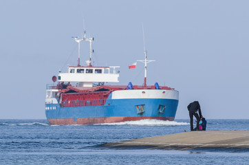 SEASCAPE - People on breakwater and freighter sailing on the sea © Wojciech Wrzesień