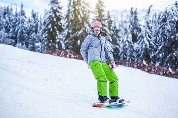 woman snowboarder skiing in the mountains