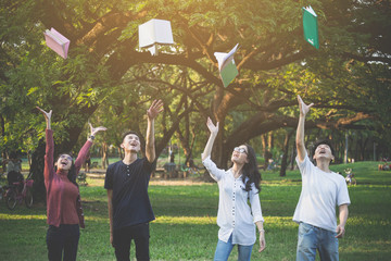 Group of highschool peoples throw the book after finish exam or report in park