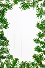 Christmas fir tree twigs on the top of white wooden table, flat lay style