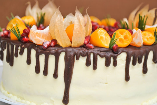 White Cream Icing Cake with Fruits and Chocolate and fizaliss flowers naked cake on white background
