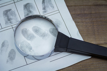 Fingerprints on paper with a magnifying glass. Take it from the suspect