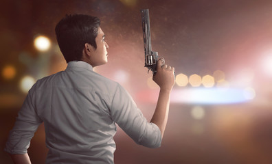 Back view of asian man in police unifrom holding guns