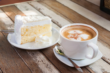 Coffee and cake are placed on a wooden table.