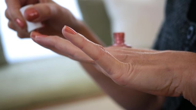 Close up of woman applying Nail polish to her hand