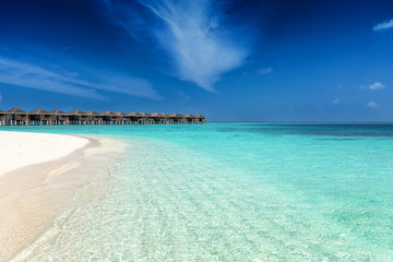 Strand auf den Malediven mit türkisem Meer, feinem Sand und tiefblauem Himmel