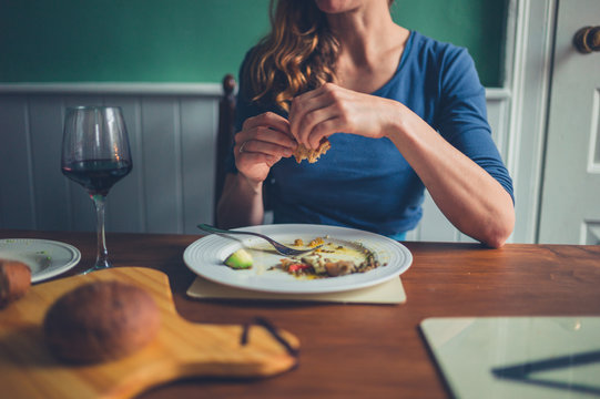 Young woman eating a meal at table