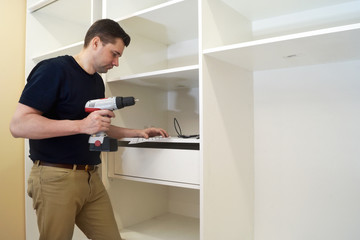 Fototapeta premium Man with screwdriver installing new furniture.