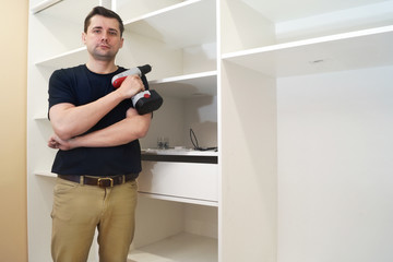Service man near new wardrobe at the time of installation.