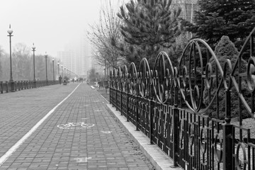 Street fence in fog, autumn season, street light background