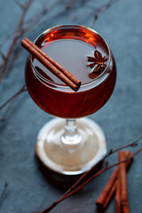 Sweet mulled wine in glass, decorated spices.