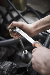 Young mechanic repair a car at a garage