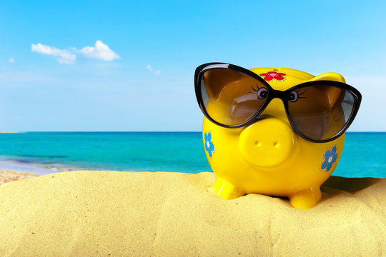 Piggy bank on a beach. Vacation savings concept