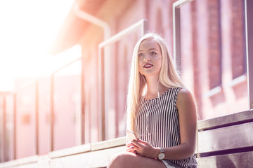 Pretty young girl listening music in the glowing sun