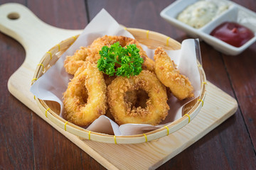 Fried calamari rings in wicker basket and sauce