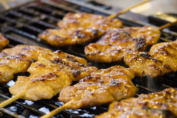 Grilling spiced chicken, roasted chicken at street food vendor market, Thai style food.