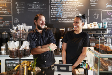 Male And Female Baristas Behind Counter In Coffee Shop - obrazy, fototapety, plakaty