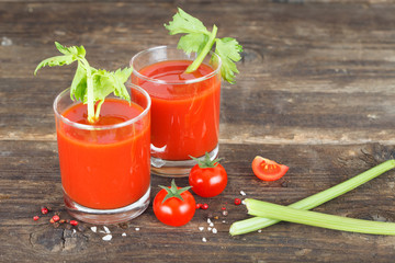 Tomato juice in glasses with celery, cherry tomato and spices