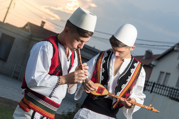 Traditionelle Musiker spielen in albanischer Volkstracht im Abendlicht