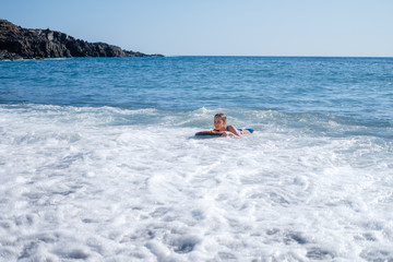 Fototapeta na wymiar girl swimming on board in ocean
